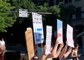 Radikale Demonstranten in Madison, WI, umgeben jungen Mann mit „Cherish Life“-Plakat – Ausrasten wegen Entscheidung von SCOTUS Roe v. Wade