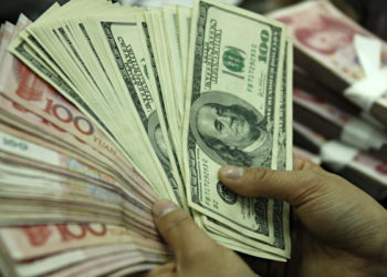A bank clerk counts U.S. dollars and Chinese yuan at a bank in Hefei, Anhui Province, China on April 13, 2010. (STR/AFP/Getty Images)