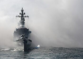 Japan's Maritime Self-Defense Force (MSDF) escort ship Kurama sails through smoke during a fleet review off Sagami Bay, Kanagawa prefecture, on Oct. 18, 2015. Thirty-six MSDF vessels and navy ships from Australia, India, France, South Korea and the United States participated in the fleet review. (TORU YAMANAKA/AFP via Getty Images)