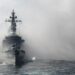 Japan's Maritime Self-Defense Force (MSDF) escort ship Kurama sails through smoke during a fleet review off Sagami Bay, Kanagawa prefecture, on Oct. 18, 2015. Thirty-six MSDF vessels and navy ships from Australia, India, France, South Korea and the United States participated in the fleet review. (TORU YAMANAKA/AFP via Getty Images)