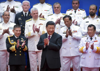 Chinese Communist Party leader Xi Jinping (center) and Chinese and foreign naval officials applaud after a group photo during an event to commemorate the 70th anniversary of the People's Liberation Army (PLA) Navy in Qingdao, in eastern China's Shandong province, on April 23, 2019. (Mark Schiefelbein/AFP via Getty Images)