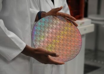 An employee holds a silicon wafer with chips etched into it at Applied Materials in Sunnyvale, Calif., on May 22, 2023. (Jim Wilson/Pool/AFP via Getty Images)
