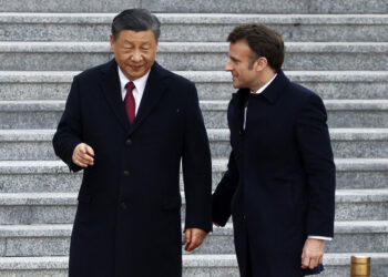 Chinese Communist Party leader Xi Jinping (L) talks with his French counterpart, Emmanuel Macron, as they arrive for the welcoming ceremony in Beijing on April 6, 2023. (LUDOVIC MARIN/AFP via Getty Images)