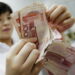 A Chinese bank worker counts stacks of 100-yuan notes at a bank in Huaibei, in eastern China's Anhui Province in this file photo taken on Aug. 4, 2010. (STR/AFP/Getty Images)