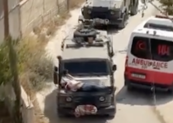 Israelische Soldaten binden verletzten Palästinenser auf ihren Jeep